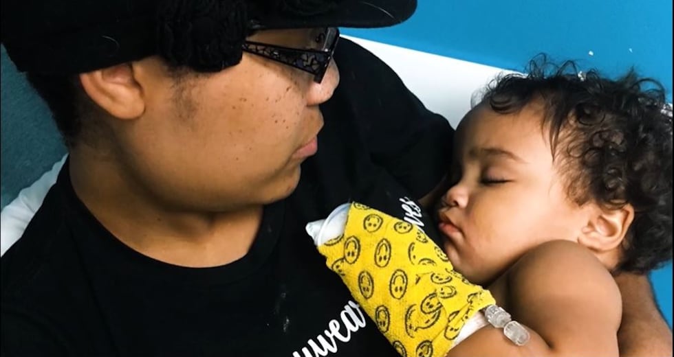 Ashley Haugen comforts her one-year-old daughter Kipley who suffered serious injuries from...