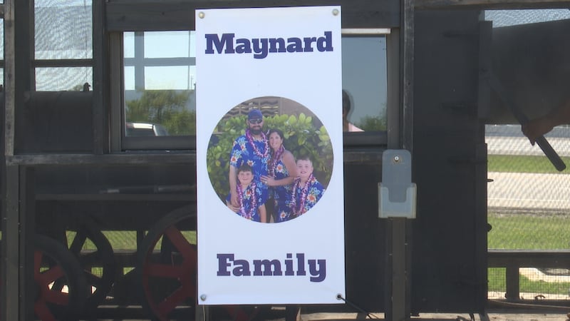 A banner of the Maynard family hangs at a barbeque benefit to help fund the search for them