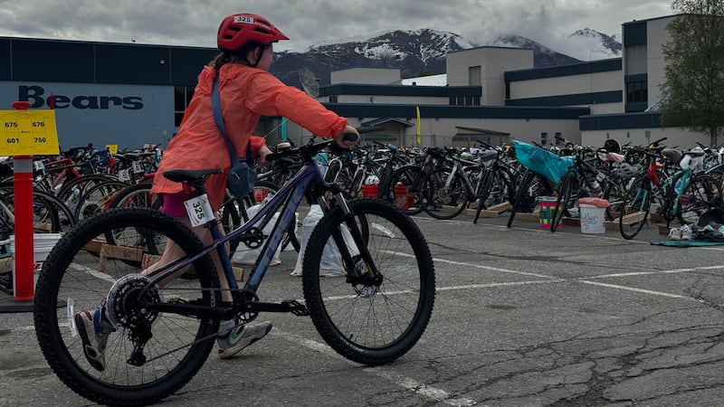 A competitor runs to the start of the bicycle course at Bartlett High School in Anchorage