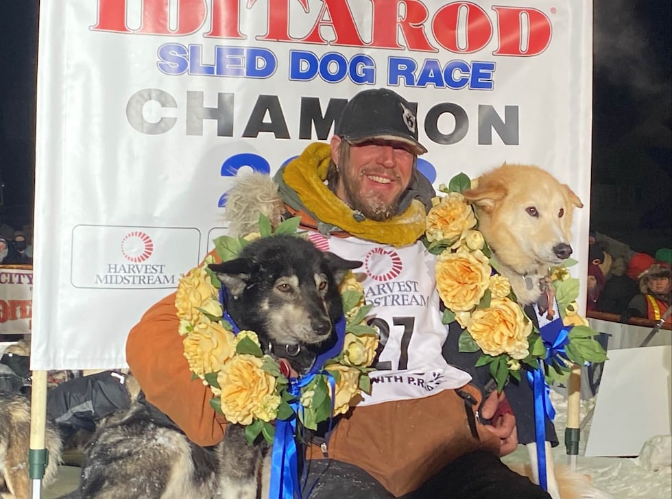 Brent Sass poses with his dog team March 15, 2022, after winning the 50th Iditarod.