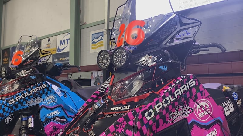 Hillarie and Timothy Gossett's sleds sit on display at the 2025 Iron Dog Banquet.