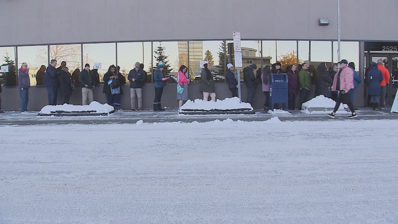 Alaskans line up outside the Division of Elections Office in Anchorage to vote early