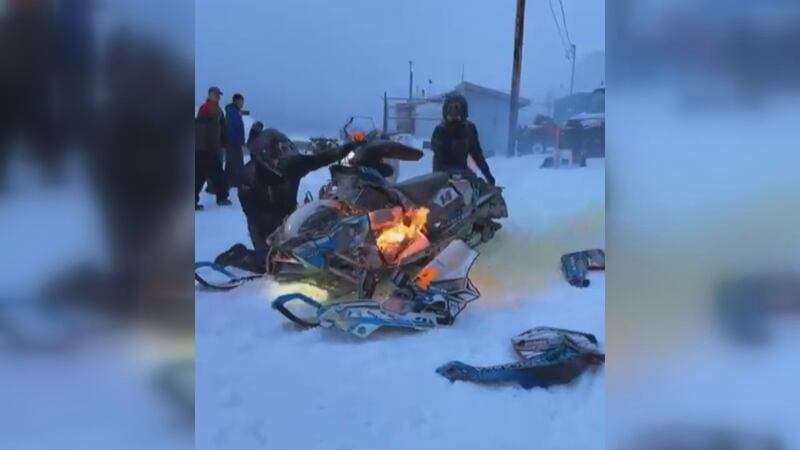 Casey Boylan, of Team 14, had his snowmachine catch fire after fueling up and leaving the...