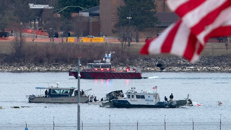A diving team and police boat is seen around a wreckage site in the Potomac River from Ronald...