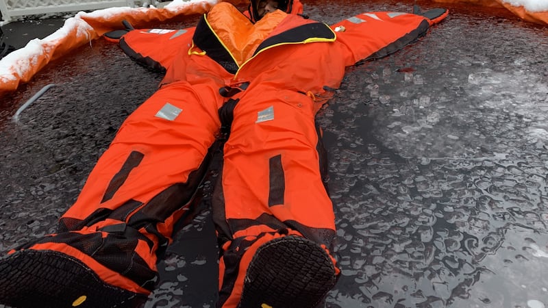 Clint Homestead floats in an ice water tank to test out a new survival suit