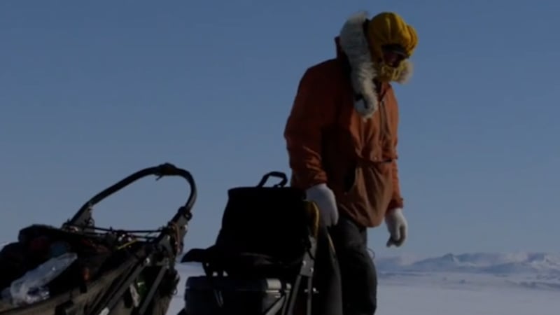Brent Sass camps with his dogs during midday on the Norton Bay sea ice